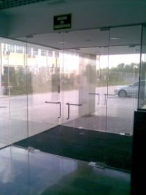 Puerta de entrada de oficina en vidrio templado con freno y herrajes